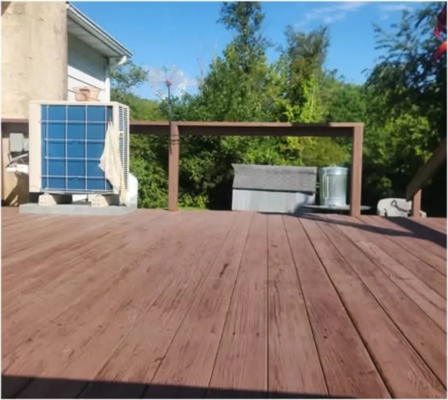 Before deck staining: weathered gray-brown boards near an HVAC unit