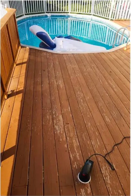 Before pool deck staining: faded, worn boards around an above-ground pool